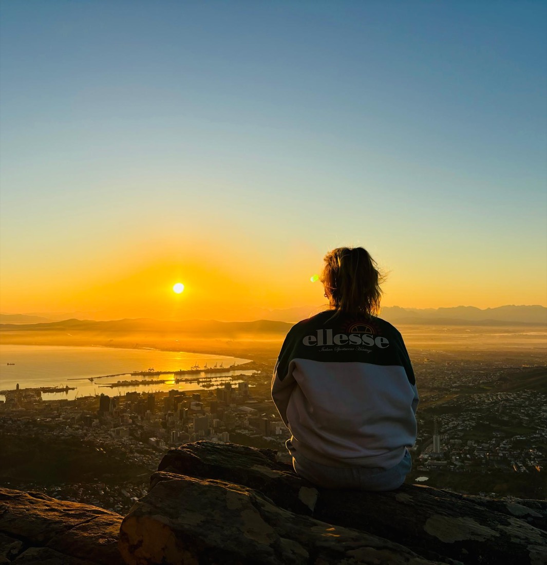 Juf Juul kijkt naar de zonsopkomst boven een stad